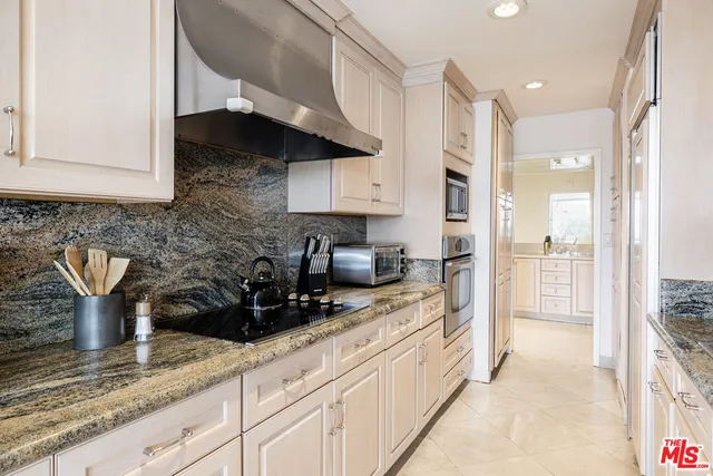 a kitchen with stainless steel appliances granite countertop a sink a stove and cabinets