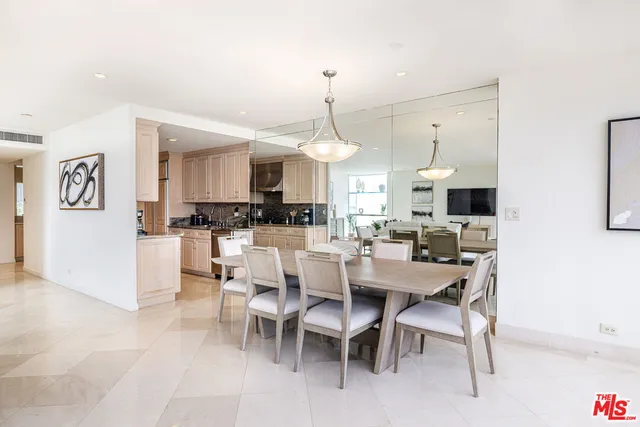 a dining room with stainless steel appliances kitchen island granite countertop a table and chairs