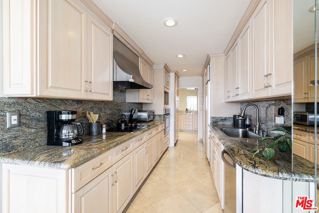 2220 Avenue Of The Stars, Unit 803 Los Angeles, CA 90067 - Photo 7 of 25 a kitchen with granite countertop a sink a stove and cabinets