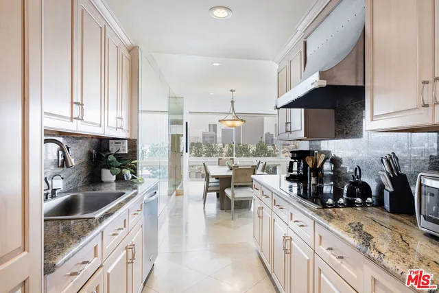 a kitchen with stainless steel appliances granite countertop a sink a stove top oven a counter space and cabinets