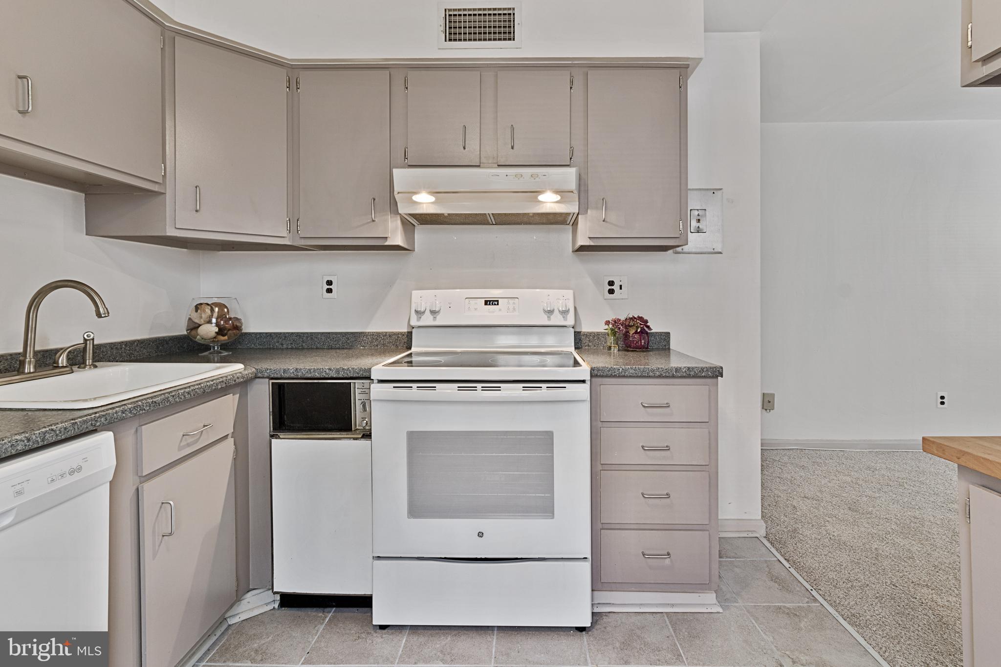3800 V Street Southeast, Unit 101 Washington, DC 20020 - Photo 6 of 28 a kitchen with white cabinets and white appliances