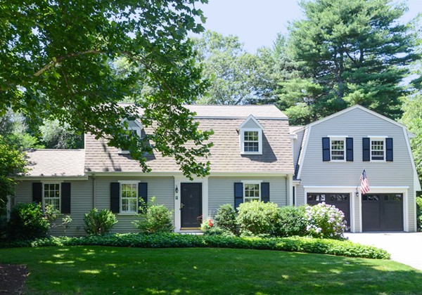 a front view of a house with a yard and trees