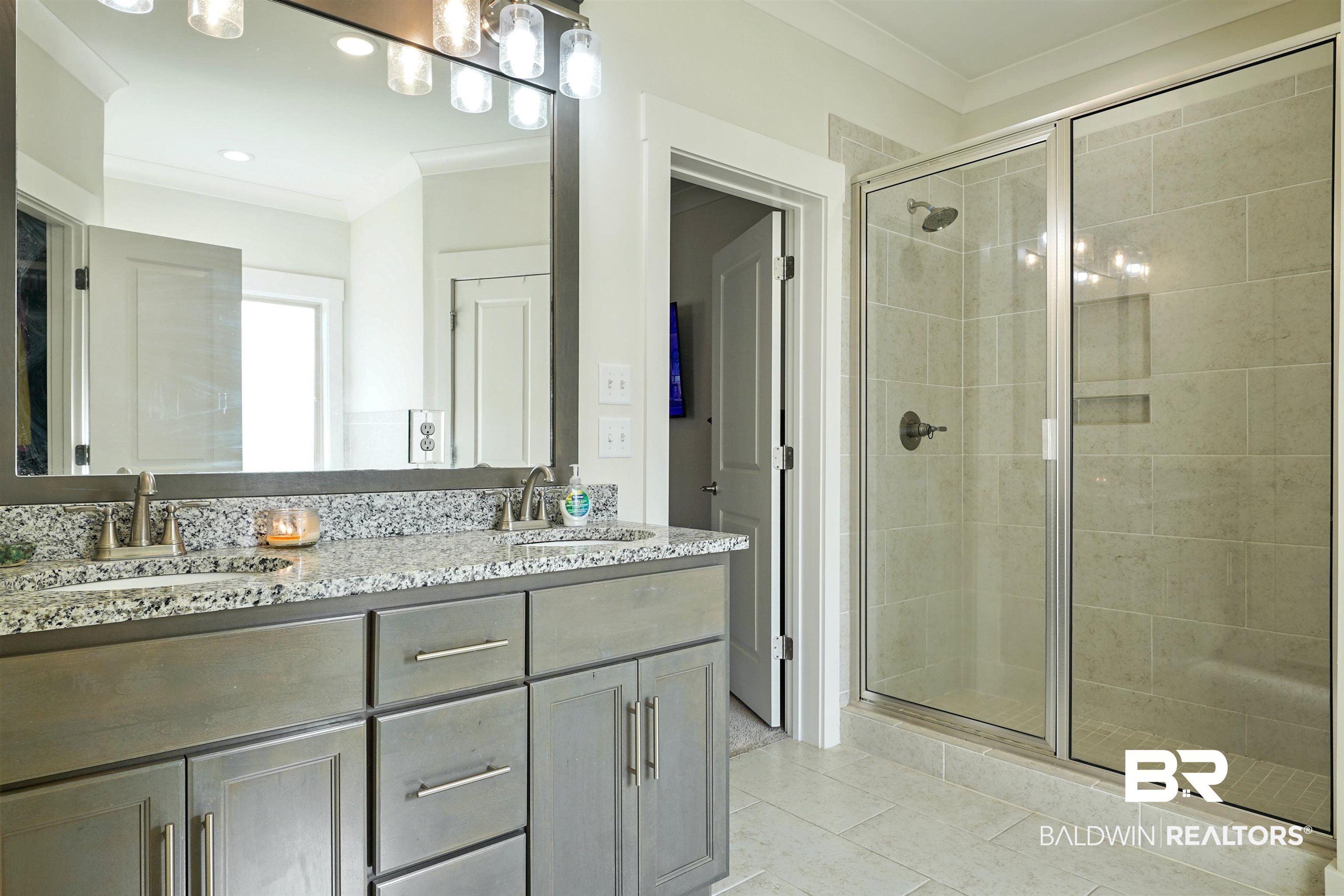 7090 Rocky Rd Loop Gulf Shores, AL 36542 - Photo 15 of 34 Bathroom with double vanity, ornamental molding, a stall shower, and a sink