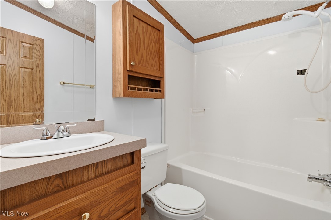 60602 Shaw Road Cambridge, OH 43725 - Photo 29 of 41 Full bath featuring vanity, bathtub / shower combination, a textured ceiling, and ornamental molding