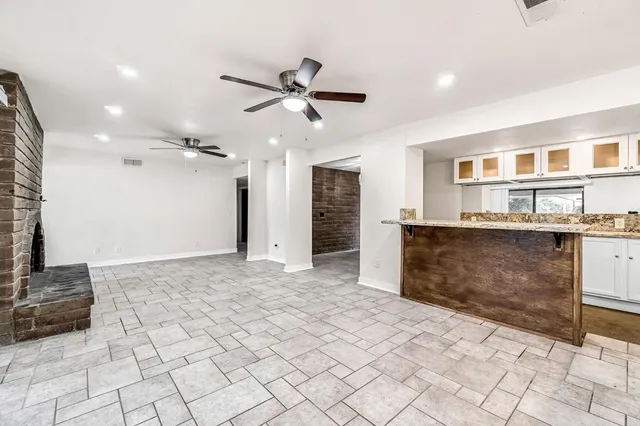 a view of a kitchen with kitchen island stainless steel appliances a sink and a counter top space