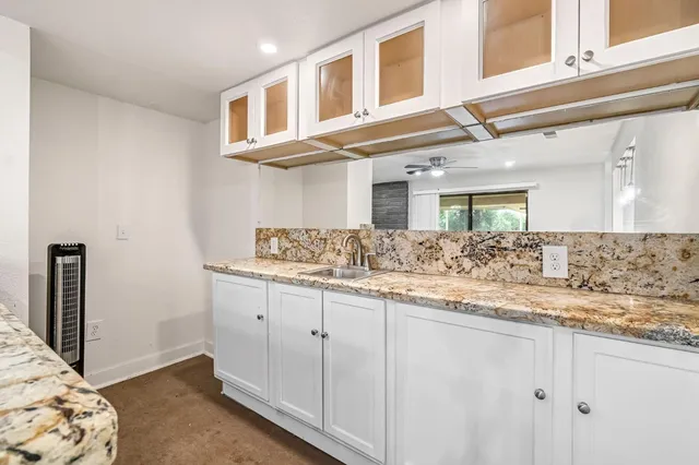 a large kitchen with kitchen island granite countertop a large counter top a sink stainless steel appliances and cabinets