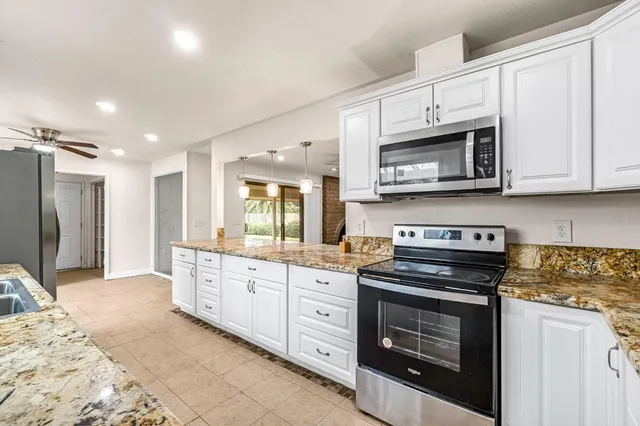 a kitchen with a refrigerator sink and cabinets