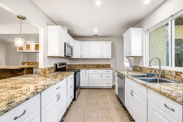 a kitchen with kitchen island white cabinets and refrigerator