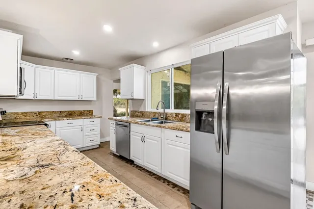 a kitchen with stainless steel appliances granite countertop a refrigerator and a stove