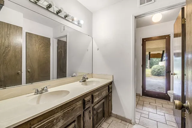 an empty room with ceiling fan and window