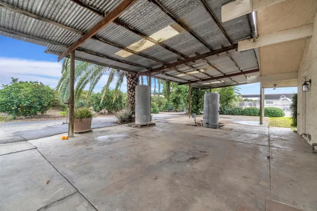 an aerial view of residential house with outdoor space and trees all around