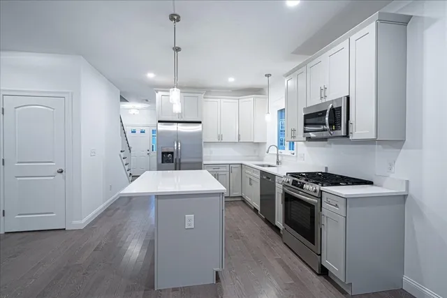 a kitchen with stainless steel appliances a stove a sink and a refrigerator