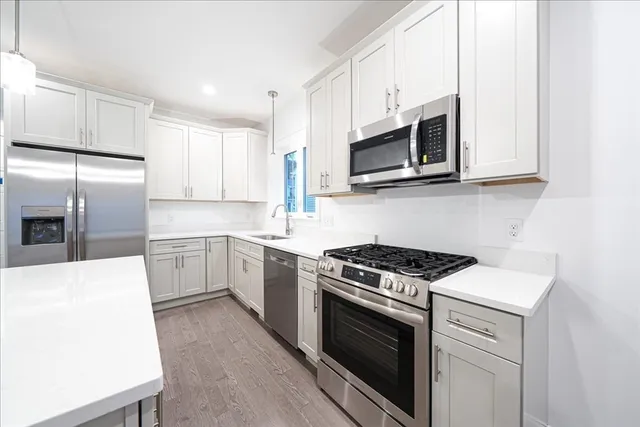a kitchen with cabinets stainless steel appliances and sink