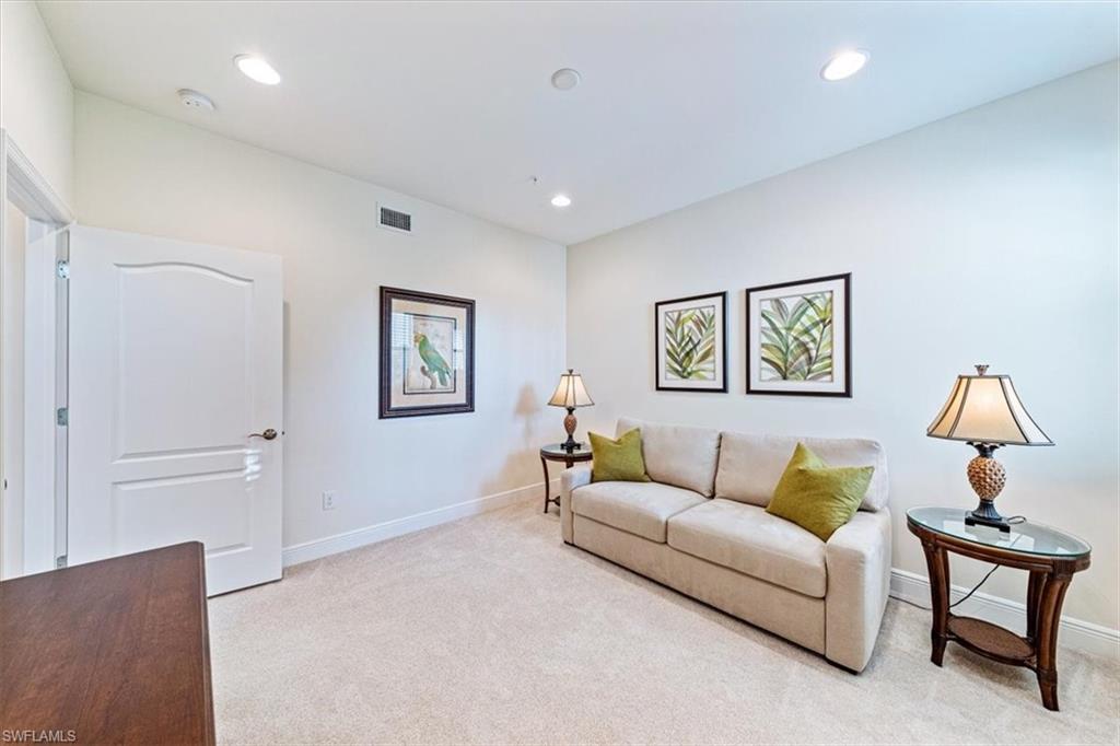6934 Avalon Circle, Unit 402 Naples, FL 34112 - Photo 18 of 28 a living room with furniture and a lamp