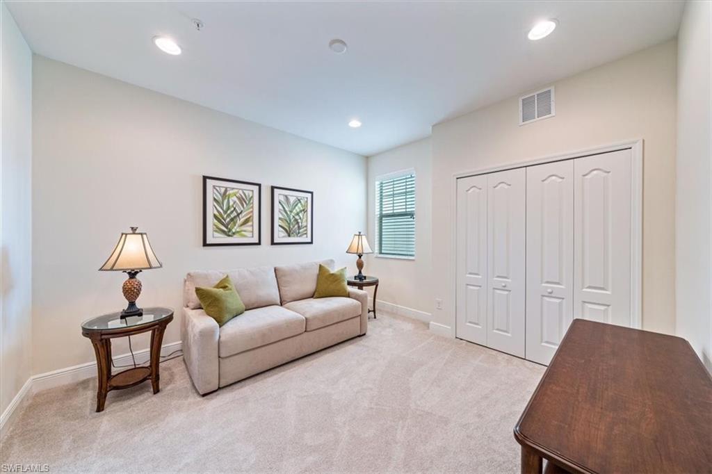 6934 Avalon Circle, Unit 402 Naples, FL 34112 - Photo 19 of 28 a living room with furniture and a lamp
