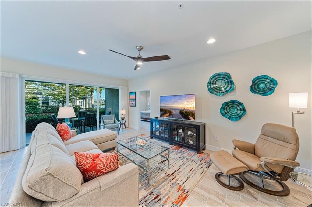 6934 Avalon Circle, Unit 402 Naples, FL 34112 - Photo 2 of 28 a living room with furniture and a flat screen tv