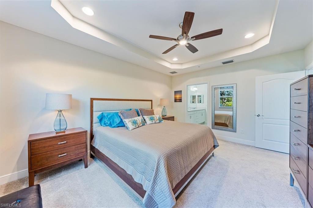 6934 Avalon Circle, Unit 402 Naples, FL 34112 - Photo 23 of 28 a bedroom with a large bed and a chandelier