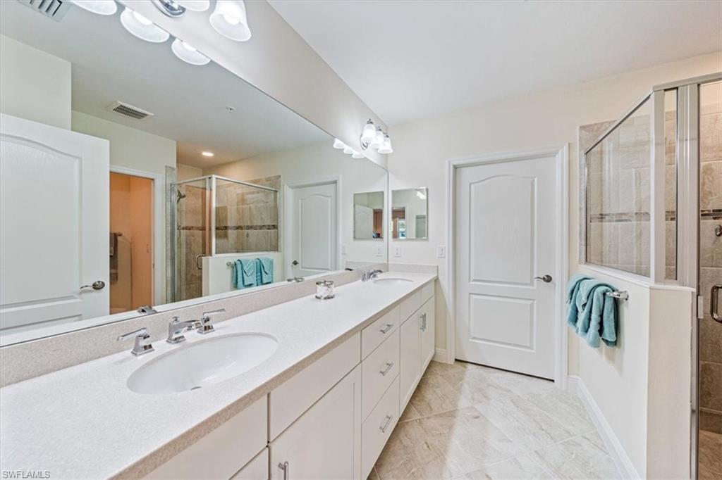 6934 Avalon Circle, Unit 402 Naples, FL 34112 - Photo 24 of 28 a bathroom with a double vanity sink mirror and double