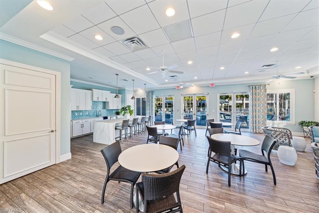6934 Avalon Circle, Unit 402 Naples, FL 34112 - Photo 27 of 28 a view of a dining room with furniture window and wooden floor