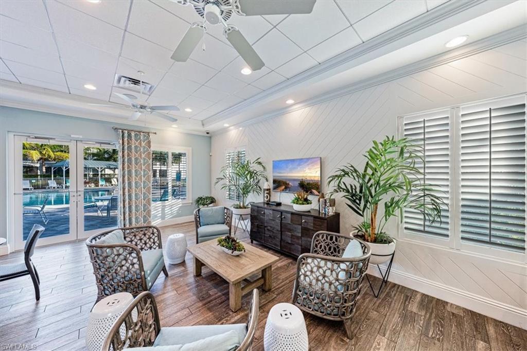 6934 Avalon Circle, Unit 402 Naples, FL 34112 - Photo 28 of 28 a living room with furniture potted plant a flat screen tv and a large window