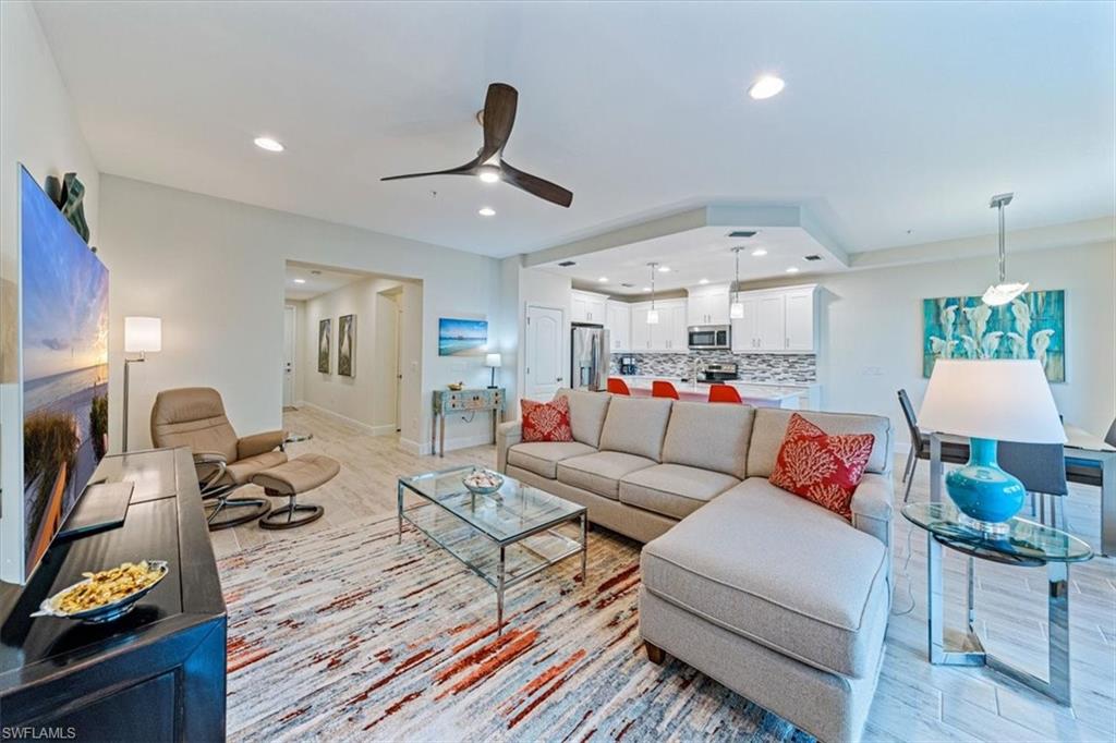 6934 Avalon Circle, Unit 402 Naples, FL 34112 - Photo 4 of 28 a living room with furniture and a chandelier