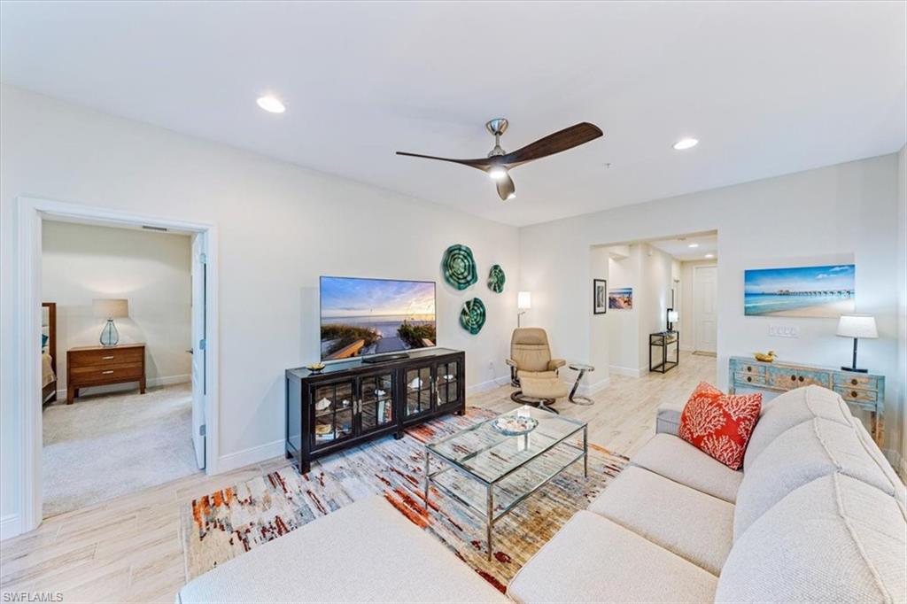 6934 Avalon Circle, Unit 402 Naples, FL 34112 - Photo 5 of 28 a living room with furniture and a flat screen tv