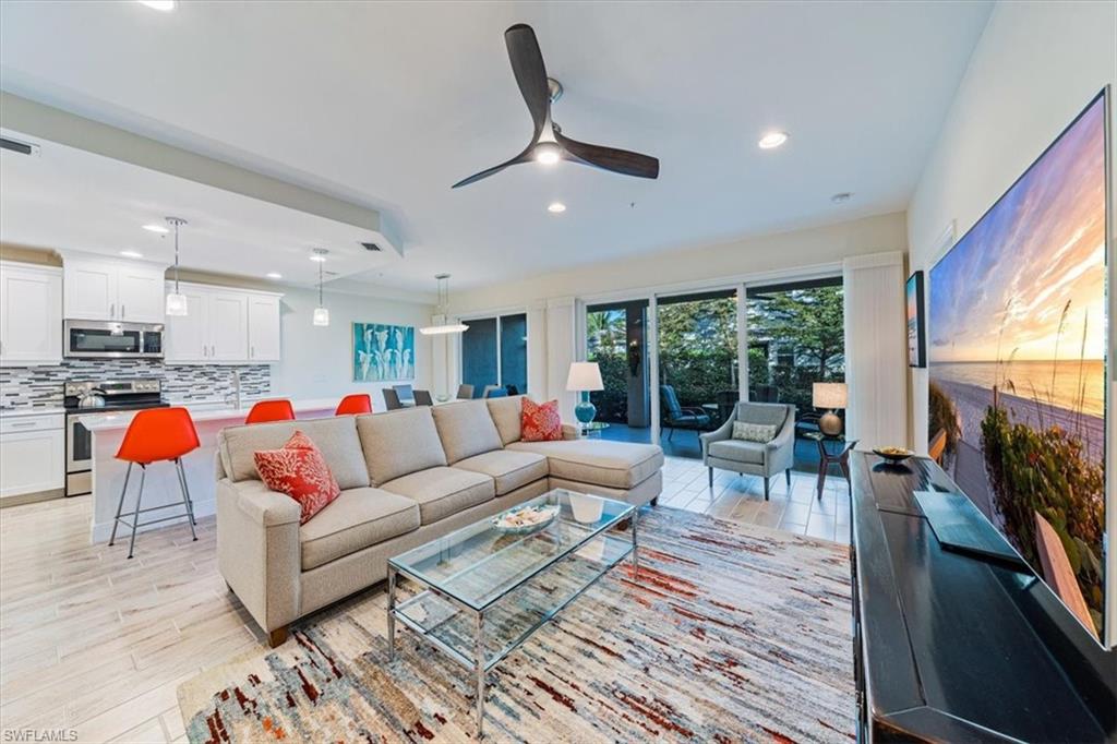 6934 Avalon Circle, Unit 402 Naples, FL 34112 - Photo 6 of 28 a living room with furniture and a fireplace