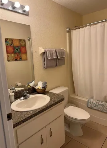 a bathroom with a granite countertop sink toilet and a mirror