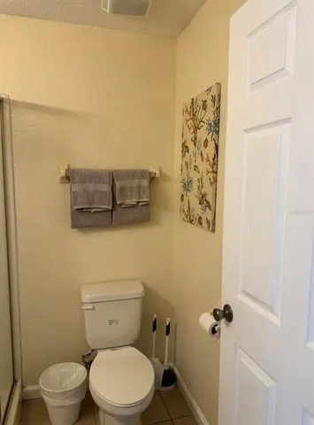 a white toilet sitting next to a shower curtain