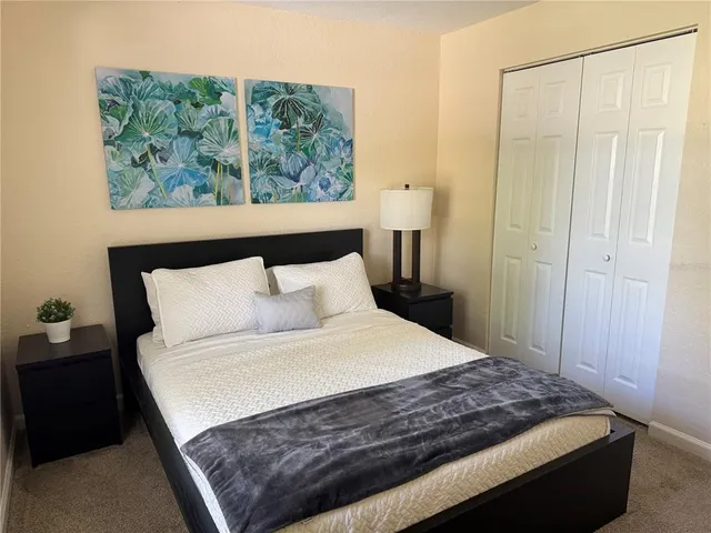 a large bed sitting in a bedroom next to a window