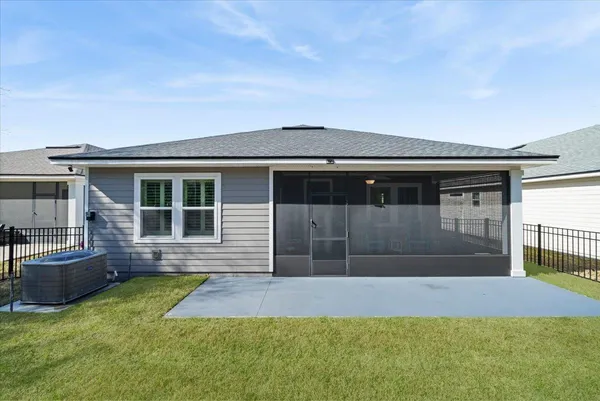 an aerial view of residential houses with outdoor space and trees
