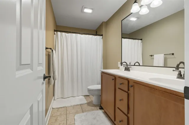 a bathroom with a double vanity sink toilet and a mirror