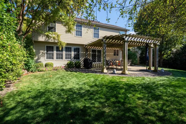 a view of a patio with a table and chairs with wooden fence and plants