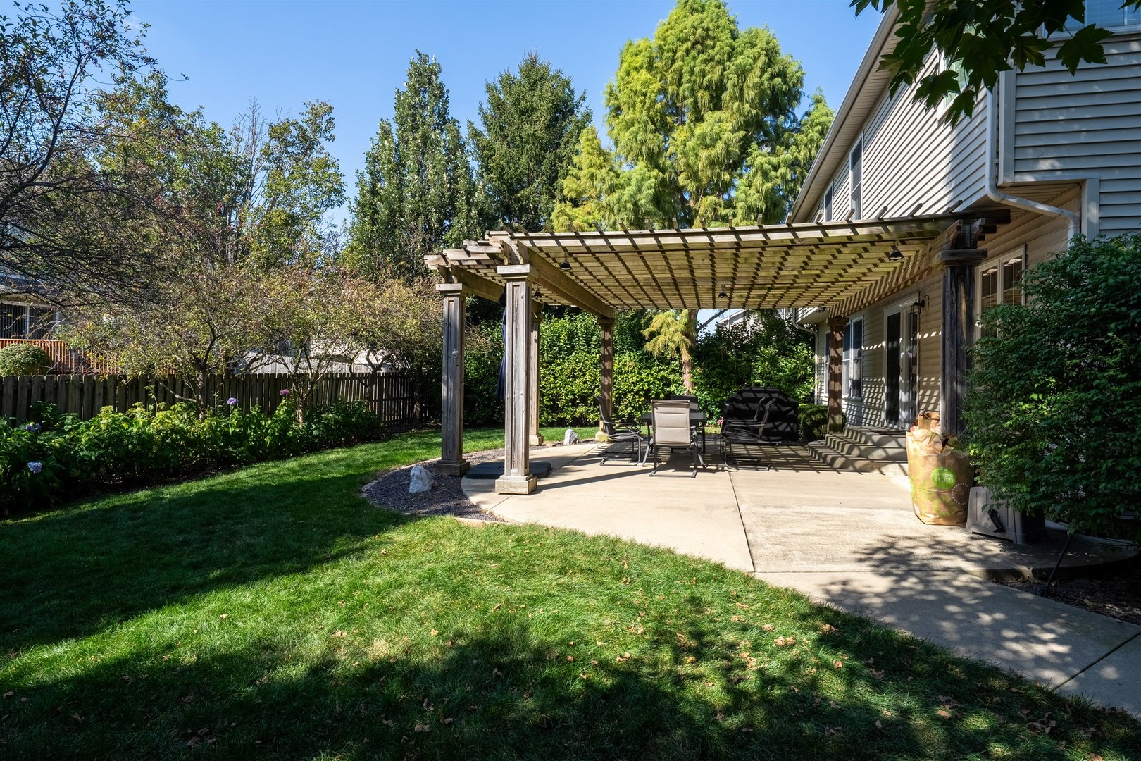 1707 Fraser Drive Normal, IL 61761 - Photo 31 of 33 a view of a patio with a table and chairs with wooden fence and plants
