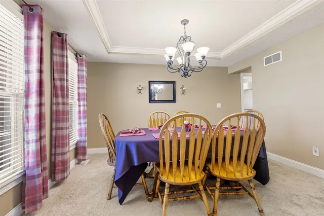 a view of a dining room with furniture and chandelier