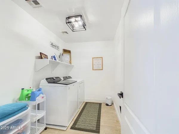 a kitchen with stainless steel appliances a dining table chairs stove refrigerator and cabinets