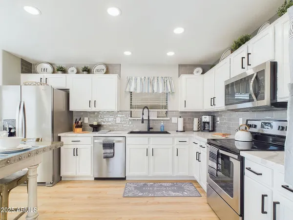 a kitchen with granite countertop white cabinets and white appliances