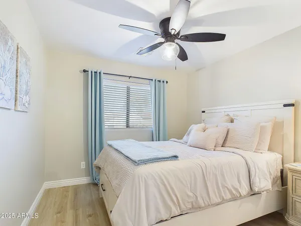 a bedroom with a bed and a ceiling fan