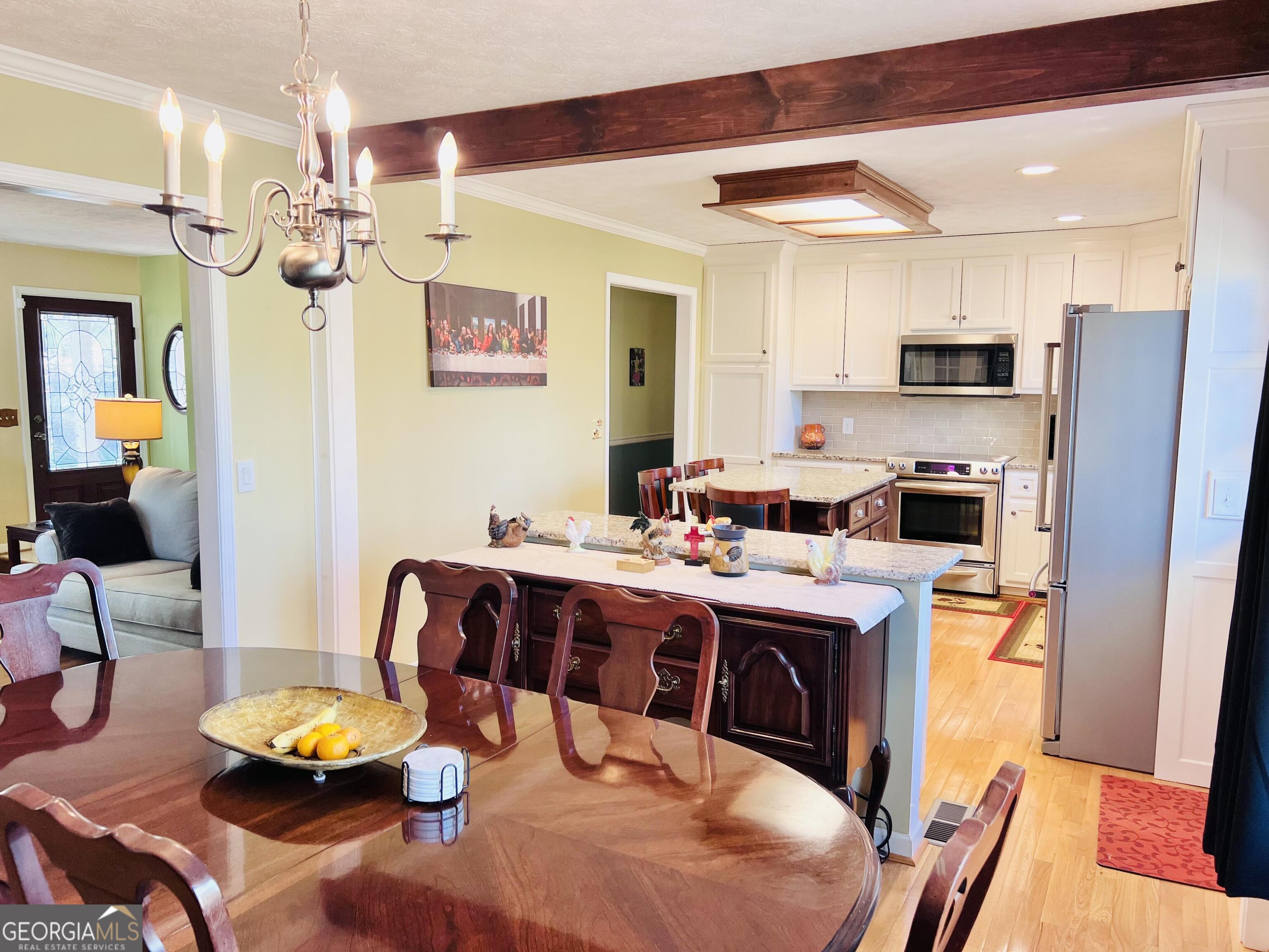 285 Wolf Den Road Royston, GA 30662 - Photo 13 of 60 a kitchen with stainless steel appliances granite countertop a sink dishwasher a stove a dining table and chairs with wooden floor