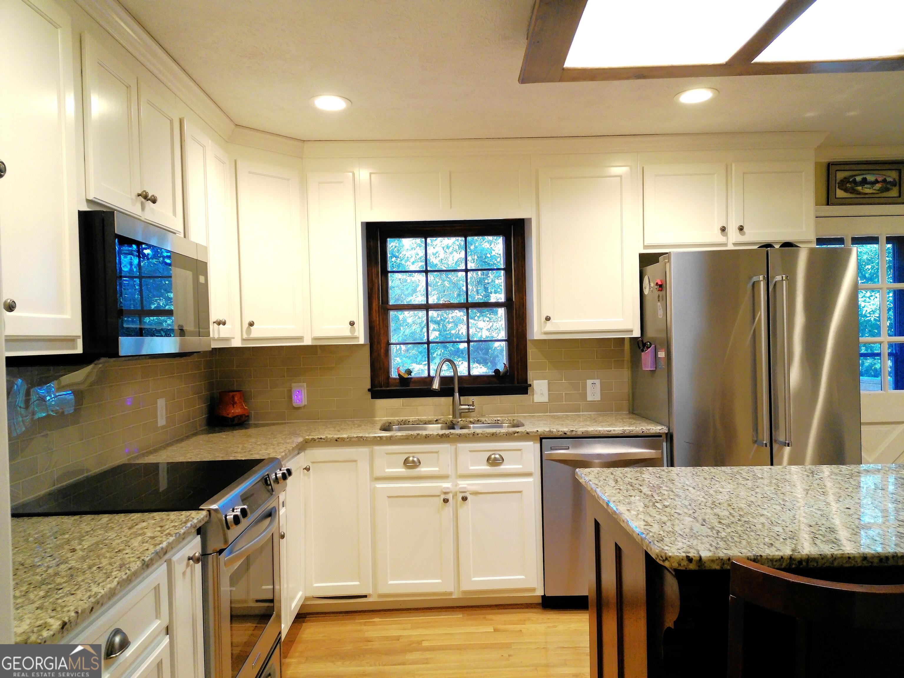 285 Wolf Den Road Royston, GA 30662 - Photo 16 of 60 a kitchen with stainless steel appliances granite countertop a sink stove and refrigerator