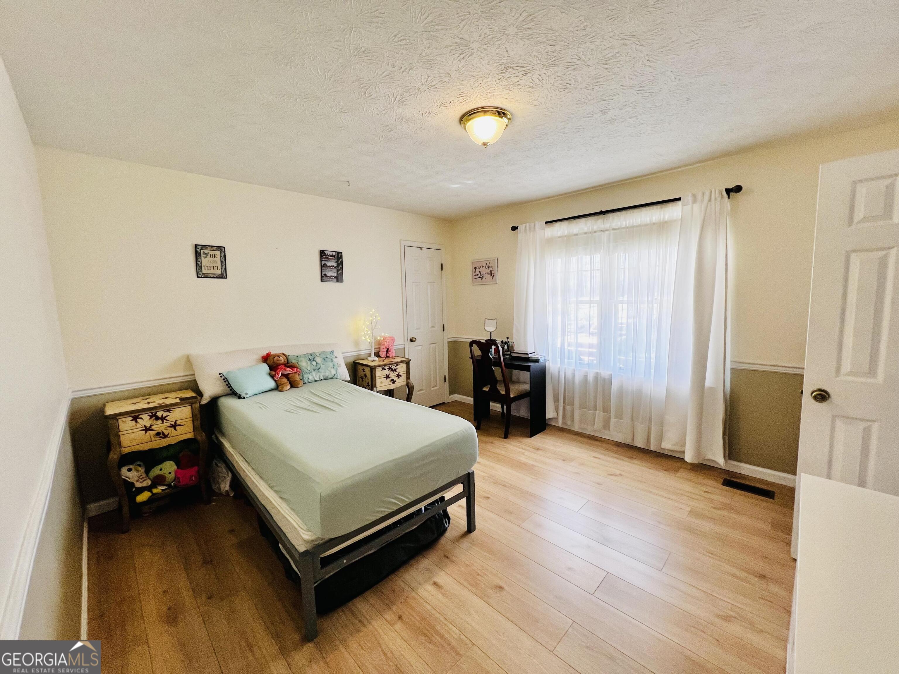 285 Wolf Den Road Royston, GA 30662 - Photo 29 of 60 a bedroom with a bed and a chair