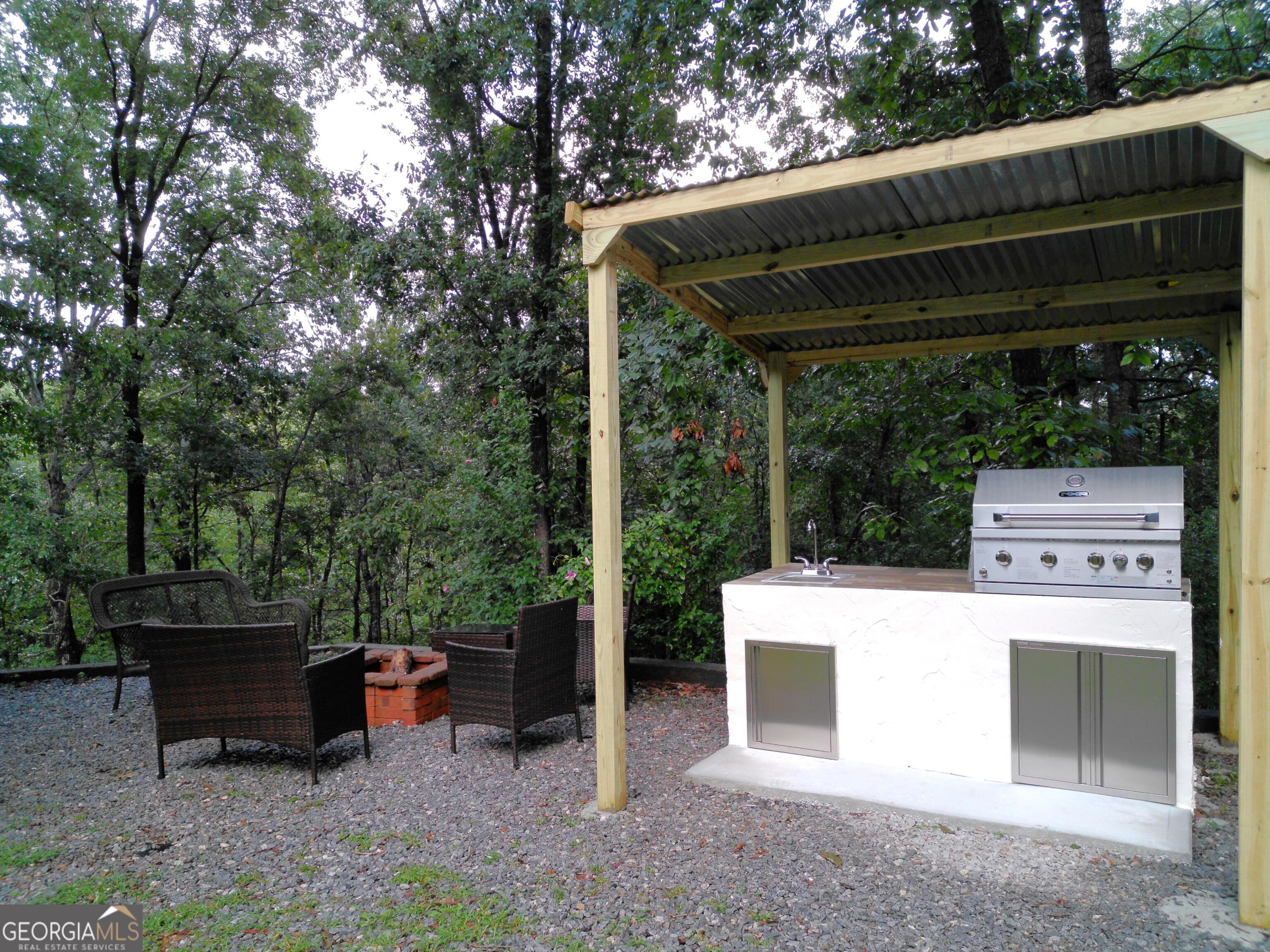 285 Wolf Den Road Royston, GA 30662 - Photo 52 of 60 a view of a patio with table and chairs a barbeque with a small yard