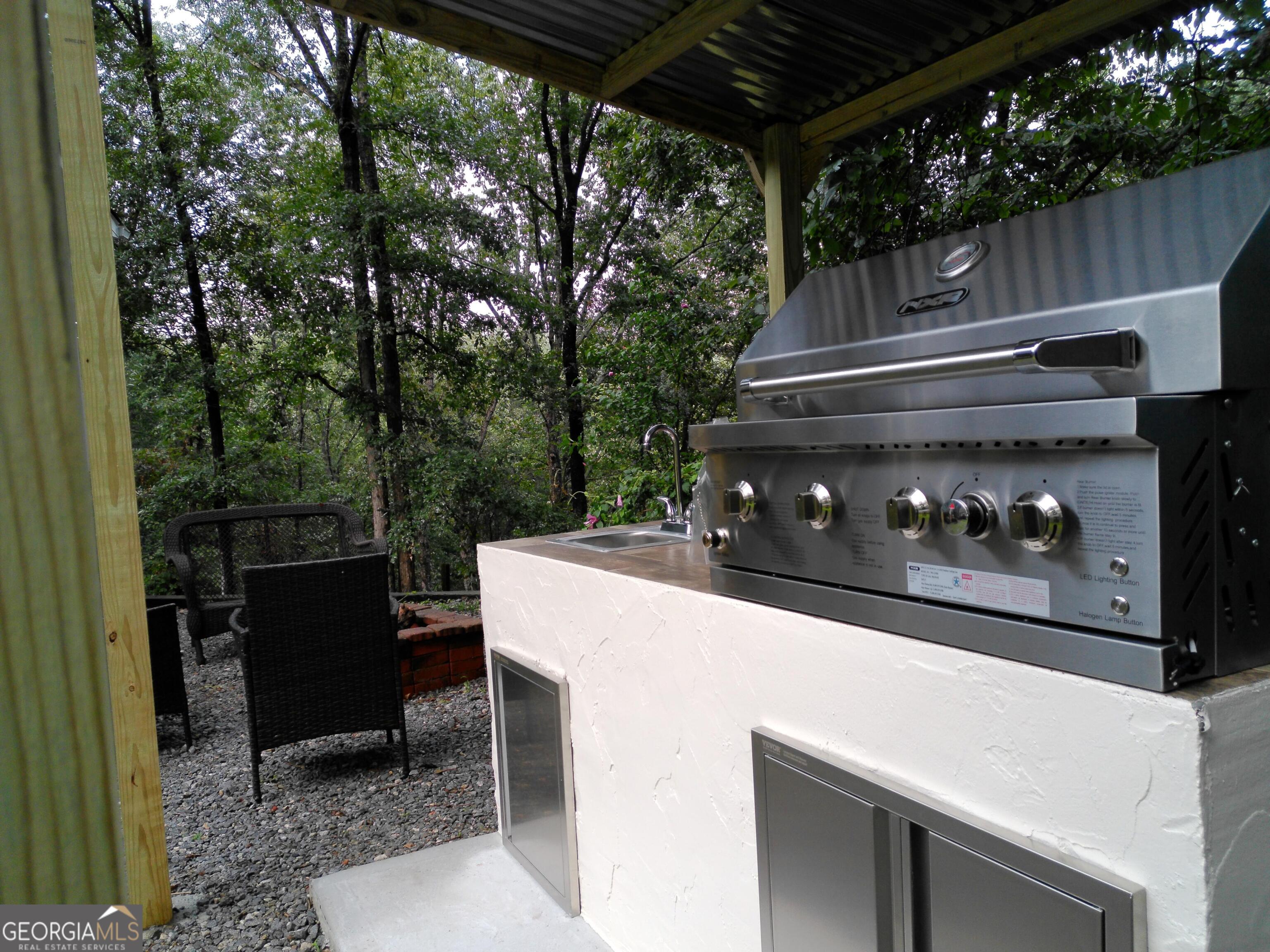 285 Wolf Den Road Royston, GA 30662 - Photo 54 of 61 a view of a patio with table and chairs a barbeque with wooden fence