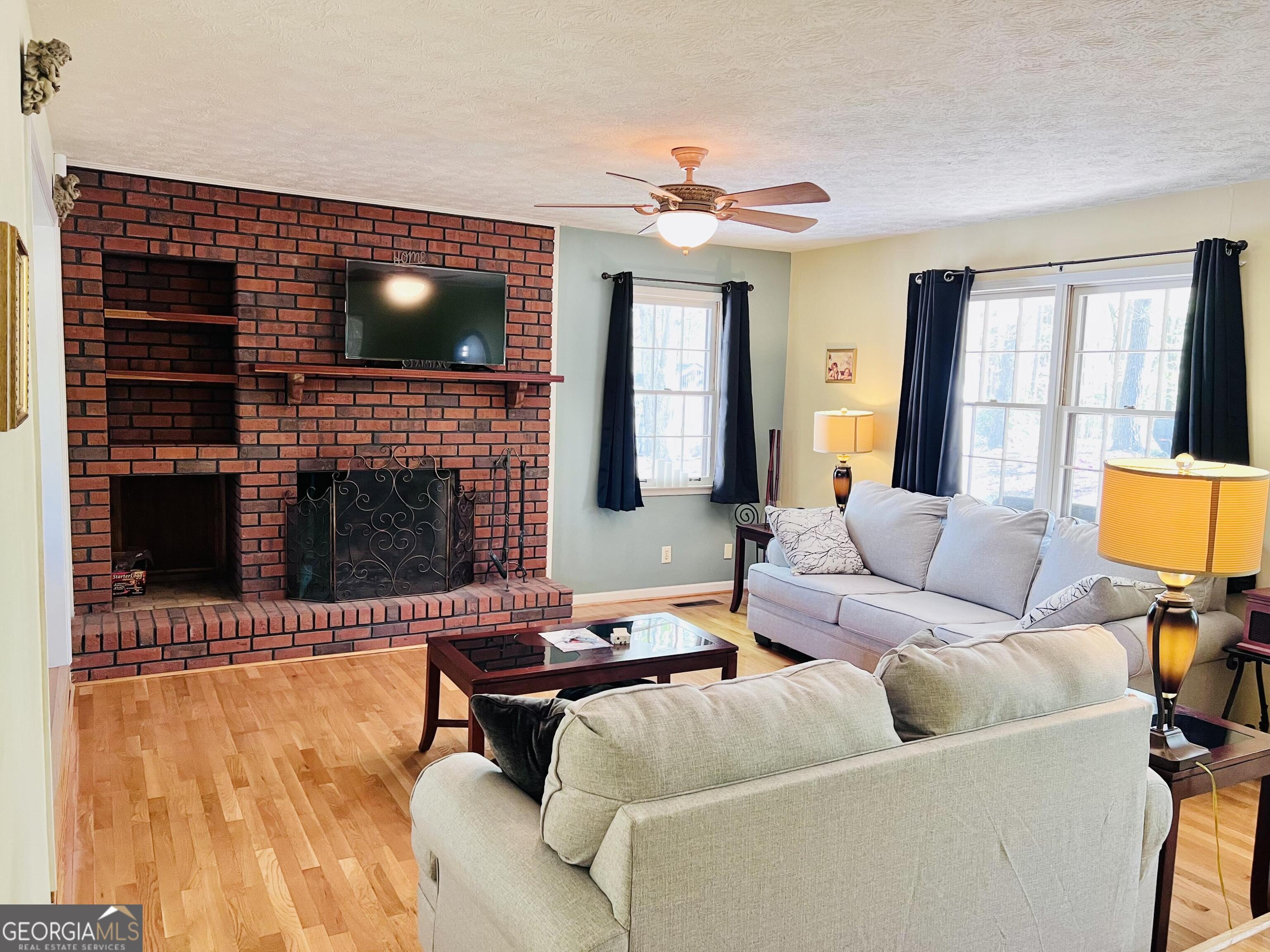285 Wolf Den Road Royston, GA 30662 - Photo 10 of 61 a living room with furniture a flat screen tv and a fireplace