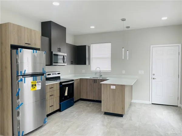 a kitchen with stainless steel appliances a refrigerator sink and stove
