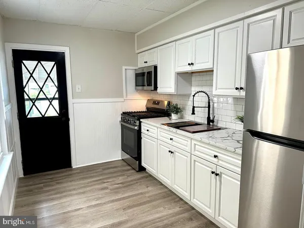 a kitchen with stainless steel appliances a refrigerator stove microwave and sink
