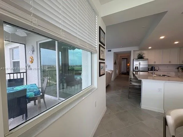 a kitchen with stainless steel appliances granite countertop a refrigerator a oven and a view of living room