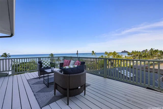 a balcony with wooden floor table and chairs
