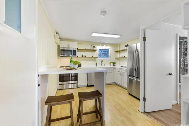 a kitchen with white cabinets and stainless steel appliances