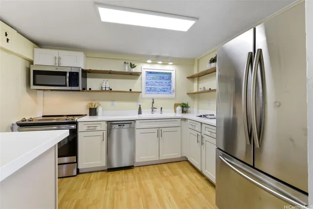 a kitchen with stainless steel appliances a refrigerator sink and microwave